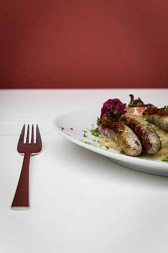 Grilled Sausages with Sauerkraut and Salad on White Plate