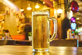 Cold Beer Mug On Wooden Table In Warm Bar Setting