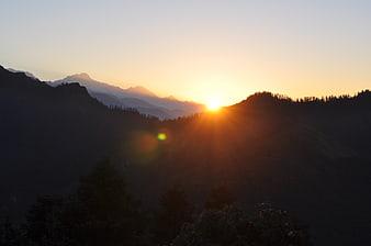 Sunrise over mountain ridges with lens flare