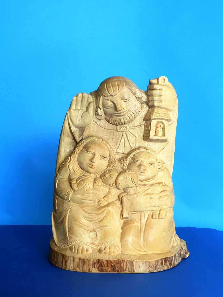 Wooden Nativity Sculpture on Blue Background