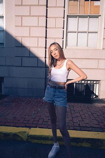 Young Asian Woman in Streetwear Posing on Urban Sidewalk