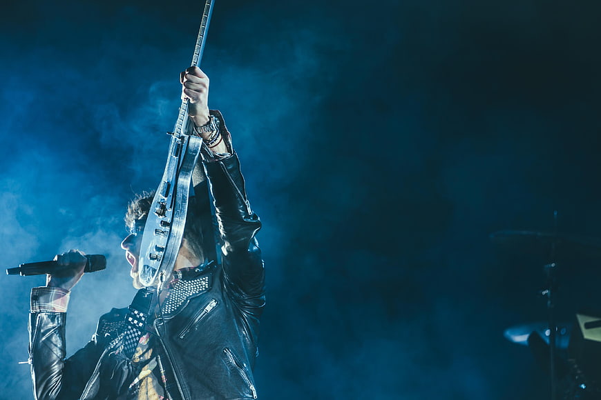 Rock singer holding electric guitar up on stage