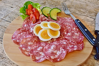 Salami Platter With Boiled Eggs, Tomatoes, And Cucumbers On Wooden Board