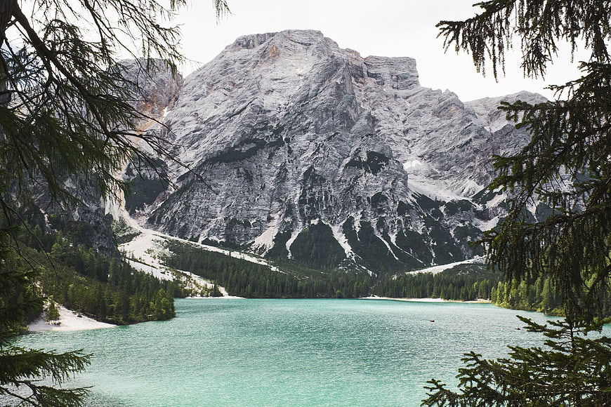 Turquoise alpine lake framed by pine trees and rocky mountain