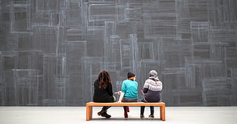 Three people viewing large chalk art installation in gallery