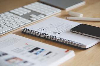 Wireframe Sketches and Smartphone on Wooden Desk