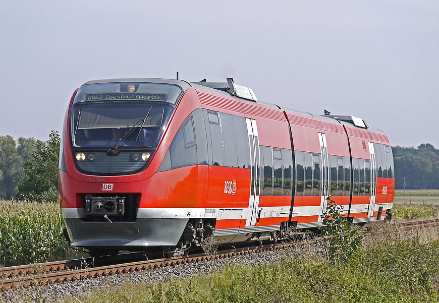 Red Regional Express Train Traveling Through Countryside