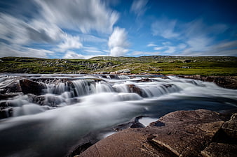 Long Exposure Waterfall Flowing Over Rocks In Norway