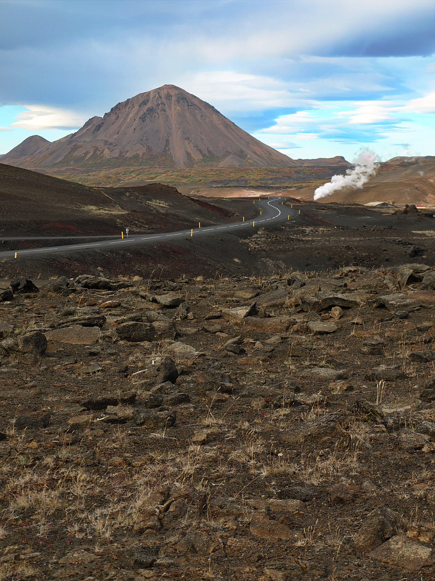Winding Road Through Volcanic Landscape with Mountain and Steam