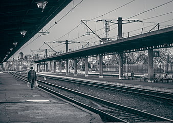 Man Walking Alone on Empty Train Station Platform