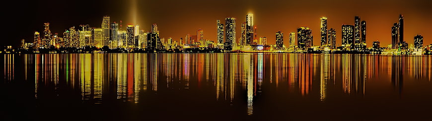 Panoramic Miami Skyline at Night with Water Reflections