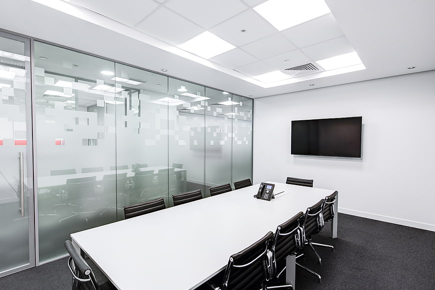 Modern empty conference room with glass walls and white table