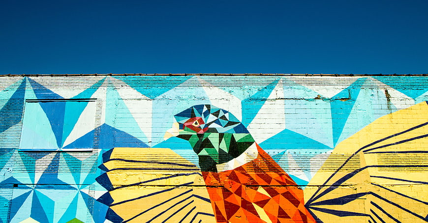 Colorful Geometric Bird Mural on Brick Wall