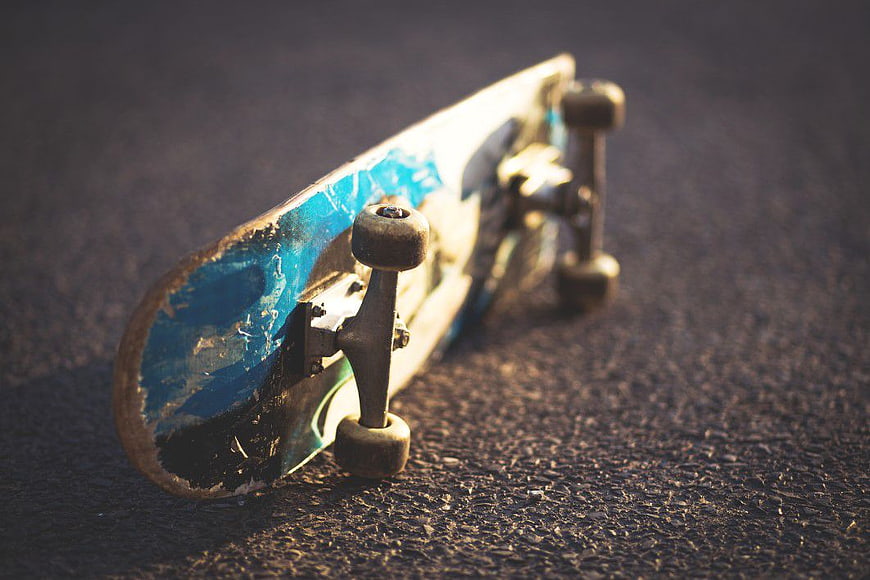 Worn Blue Skateboard on Asphalt