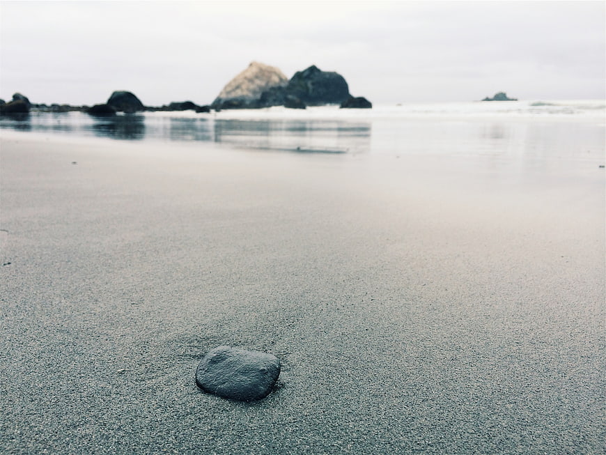 Minimalist Beach Scene with Smooth Sand and Distant Rocks