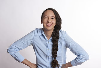 Confident smiling woman with long braid in blue shirt