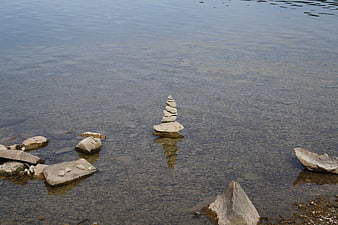 Balanced stone cairn in clear shallow lake water