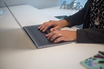Woman Typing on Laptop in Modern Office Workspace