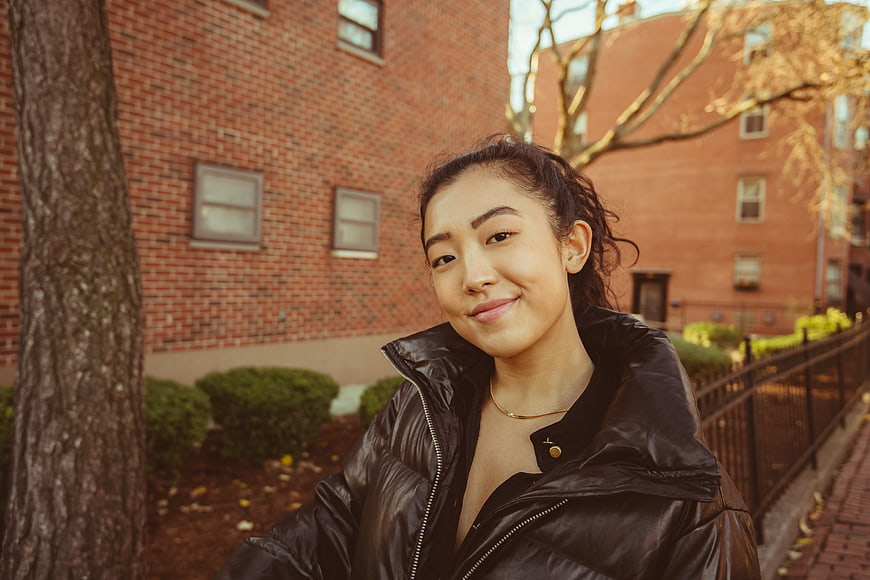 Smiling Asian Woman in Black Puffer Jacket Outdoors
