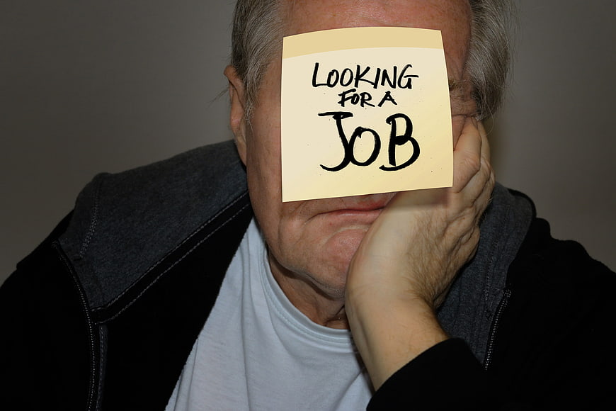 Senior man holding looking for a job sticky note over face