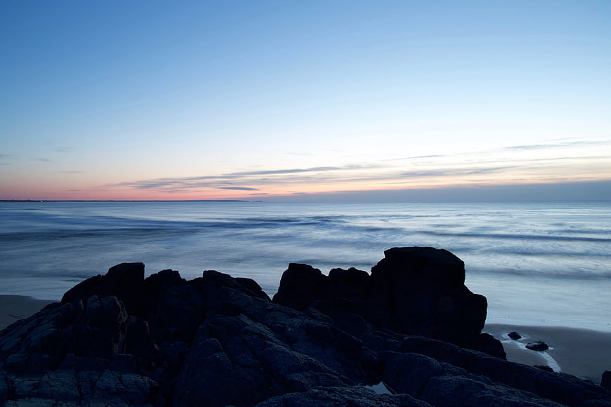 Silhouetted Rocks on Seashore at Twilight