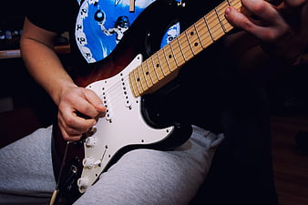Close-up of hands playing electric guitar