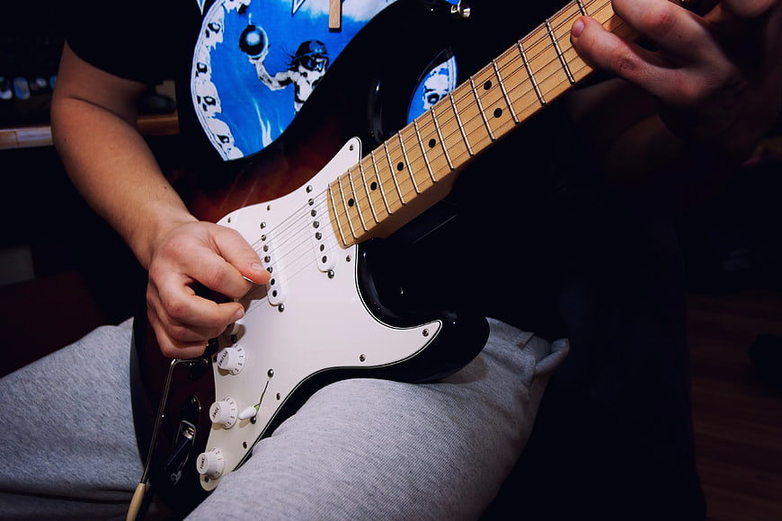 Close-up of hands playing electric guitar