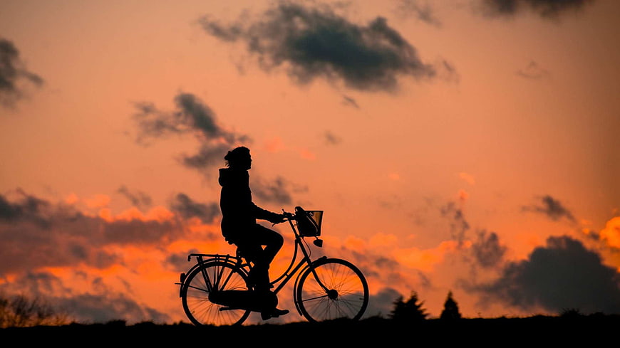 Silhouette of Woman Cycling at Sunset