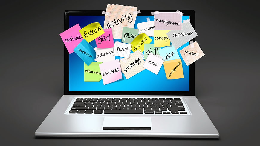 Laptop with sticky notes popping out of screen