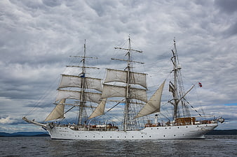White Tall Ship Sailing on Ocean Under Cloudy Sky