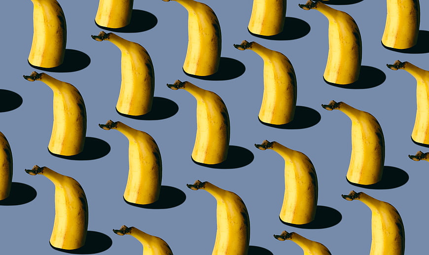 Surreal Pattern of Floating Bananas on Blue Background