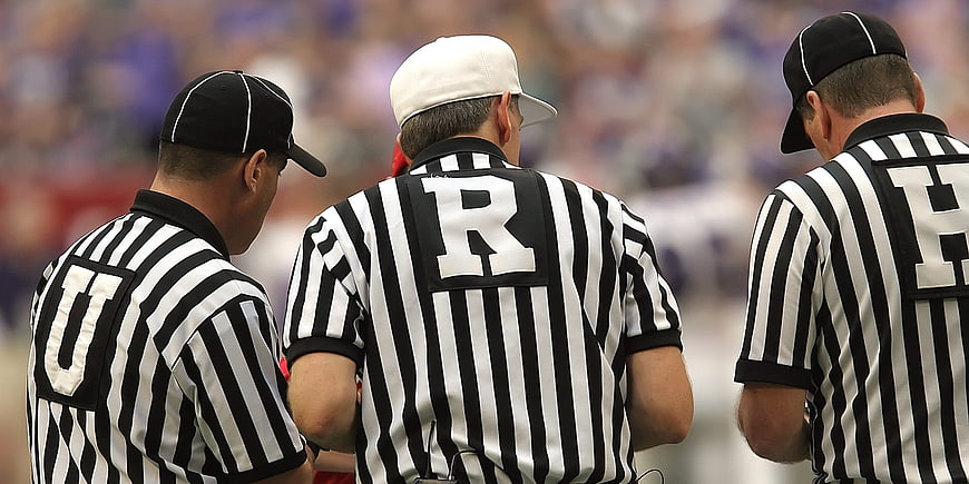 Three American Football Referees Discussing a Call