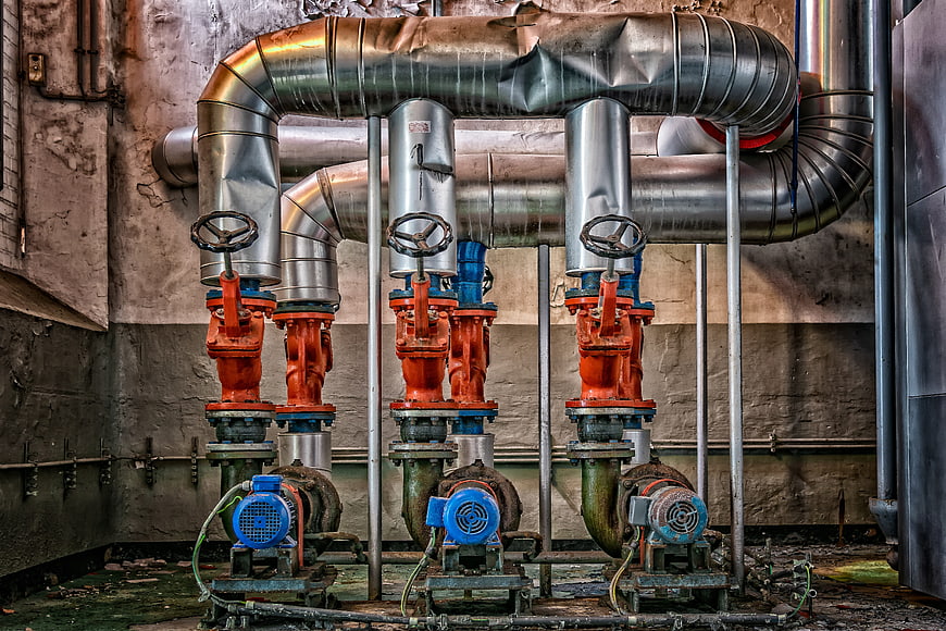 Abandoned Industrial Boiler Room With Rusty Pumps And Metal Pipes