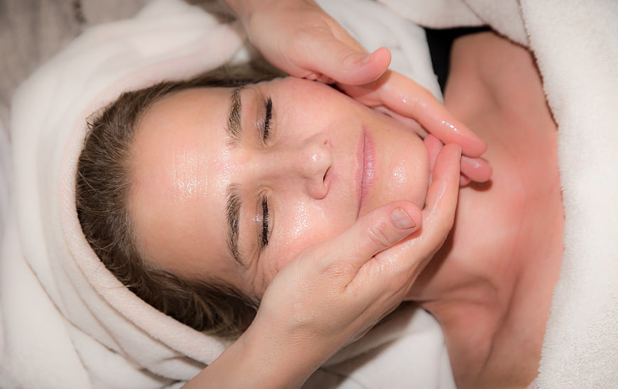 Woman Receiving Facial Massage Treatment With Oil