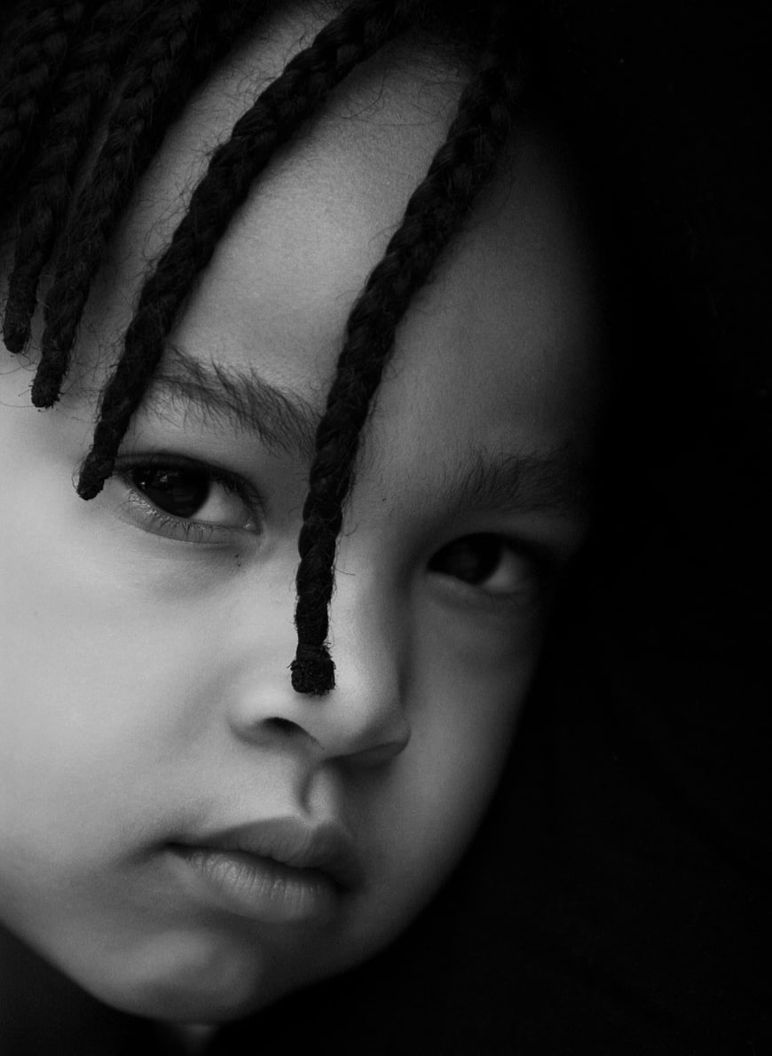 Black and white close-up portrait of a young girl with braids