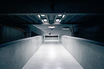 Symmetrical Concrete Corridor with Distant Figure