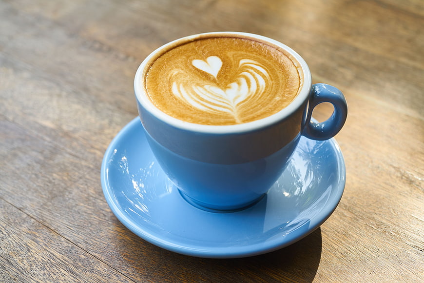 Blue Cup of Latte Art Coffee on Wooden Table