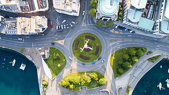 Aerial view of roundabout with airplane sculpture near harbor