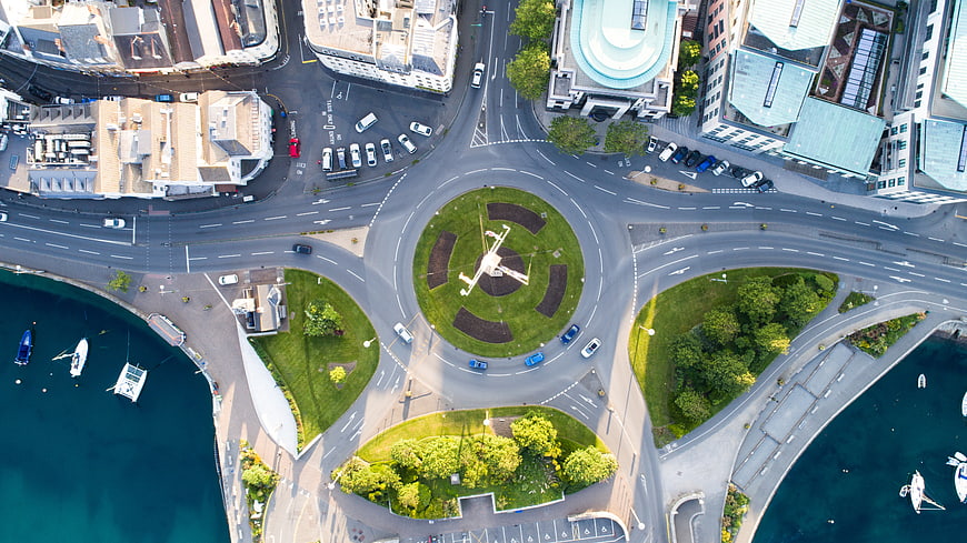 Aerial view of roundabout with airplane sculpture near harbor