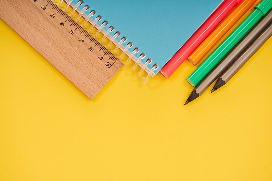 Colorful School Supplies Flat Lay on Yellow Background