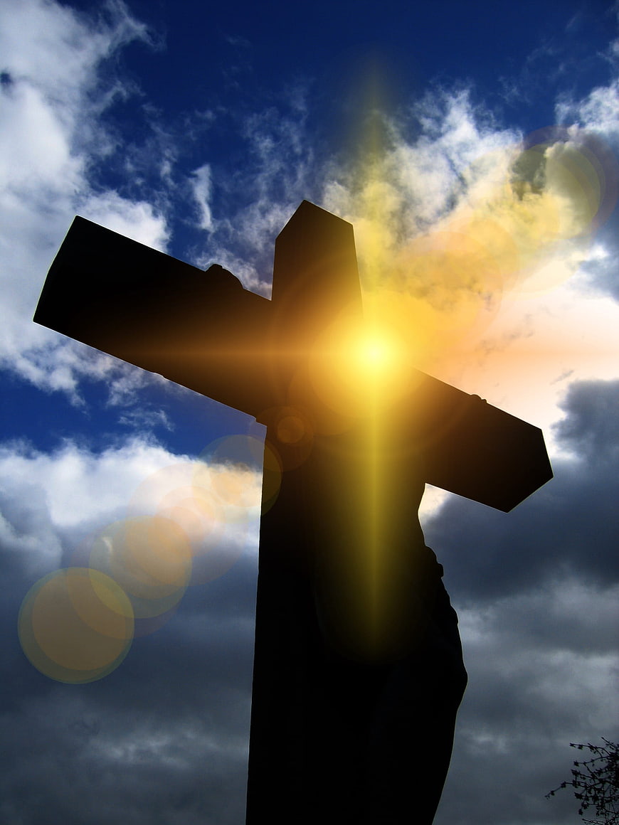 Silhouette of Jesus on Cross Against Dramatic Sky