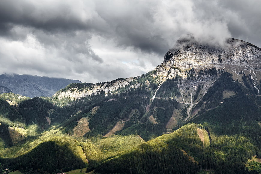 Dramatic Mountain Landscape with Clouds and Forested Valleys