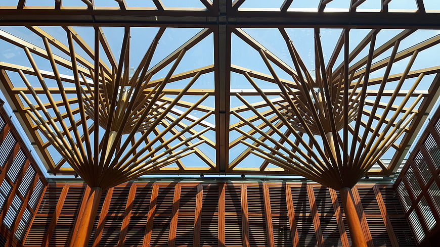 Modern wooden architectural ceiling structure with blue sky