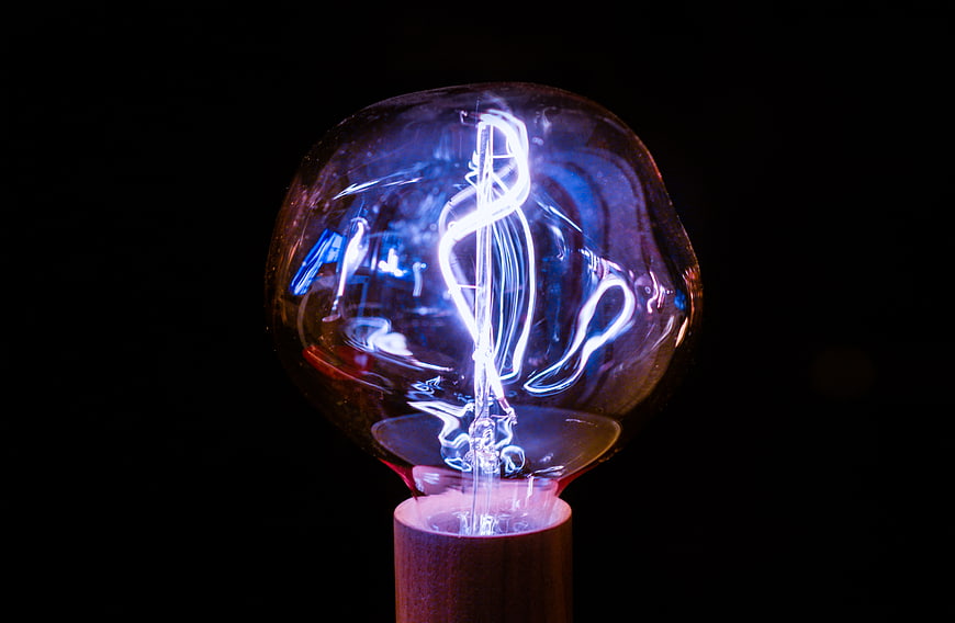 Glowing Edison Bulb with Blue Neon Light on Black Background