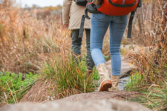 Couple hiking on trail with backpacks in autumn
