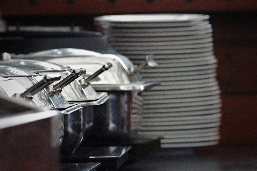 Stainless Steel Buffet Chafing Dishes And Stacked Plates
