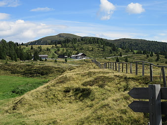 Alpine landscape with wooden fence and mountain huts