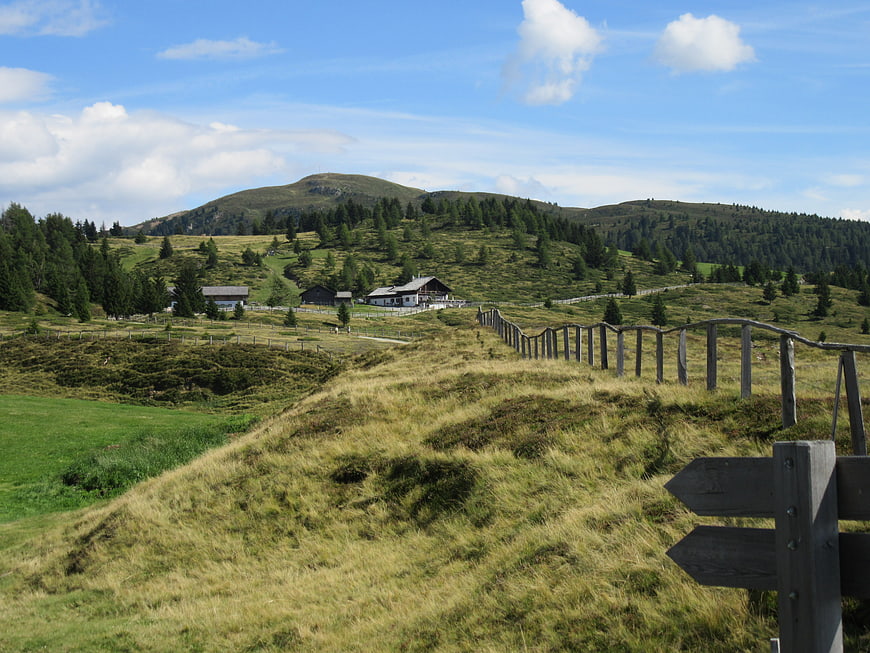 Alpine landscape with wooden fence and mountain huts