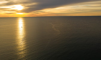 Aerial View of Golden Sunset Over Calm Ocean Horizon