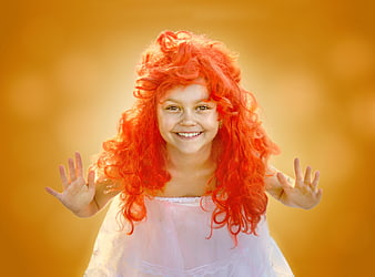 Happy Girl with Red Wig Smiling Against Golden Background